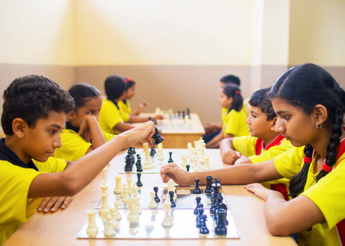 Students playing chess to enhance critical thinking and strategy skills at NewAge World School.